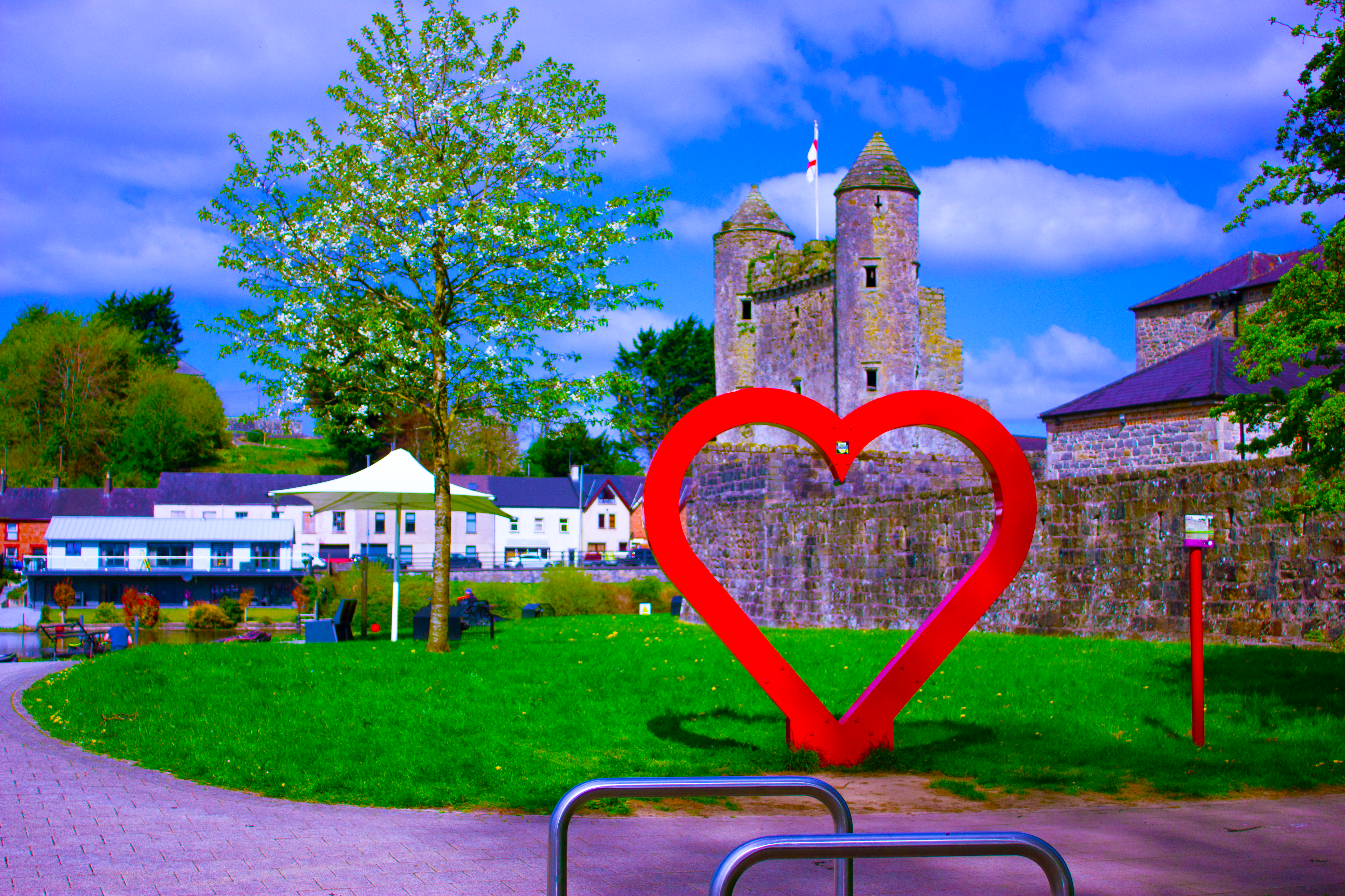 Stone castle with a red metal heart frame in front of it. 